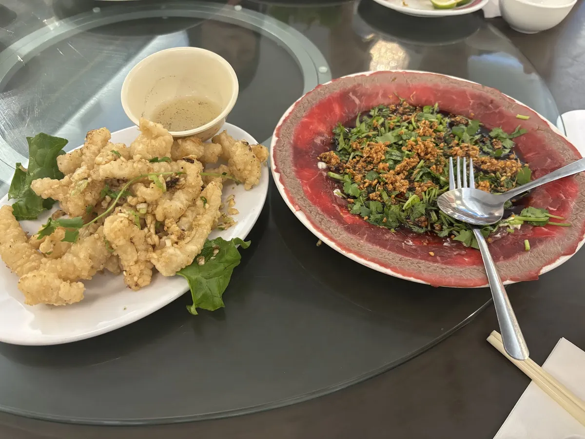 Fried calamari and beef carpaccio on a table