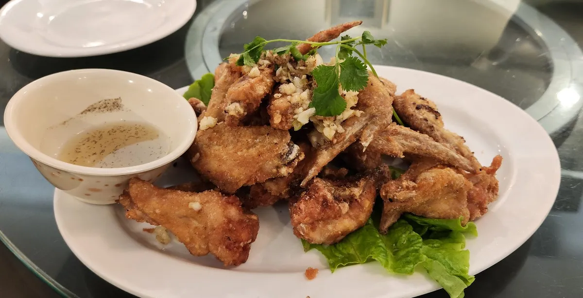 Plate of fried chicken wings with garlic and dipping sauce